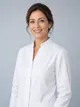 Portrait of Elena Navarro in a white clinical tunic