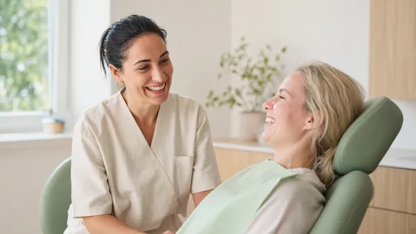 A dentist talking with a patient in the chair